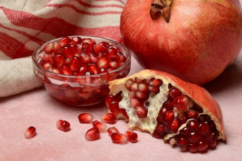 Opened pomegranate and pomegranate seeds in skin, Punica granatum