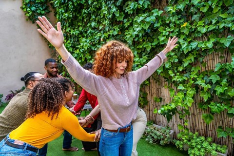 Adults participating in a group therapy session, performing a mindful movement exercise together in
