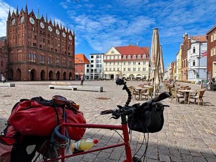 Bicycle standing in front of a historic square with old buildings and a clear sky, Stralsund,