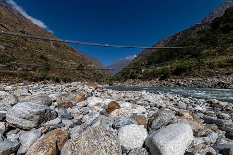 Suspension bridge made of steel cables across river valley, Tsum Valley, Himalayas, Nepal