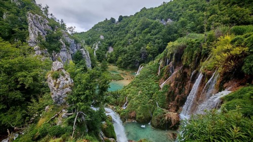 Spectacular waterfalls falling into a river nestled in green mountain scenery, Plitvice Lakes