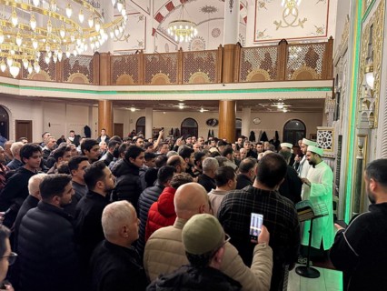 Dozens of Muslims stand in a long queue to view a sacred piece of the Kaaba curtain (Kiswa) while
