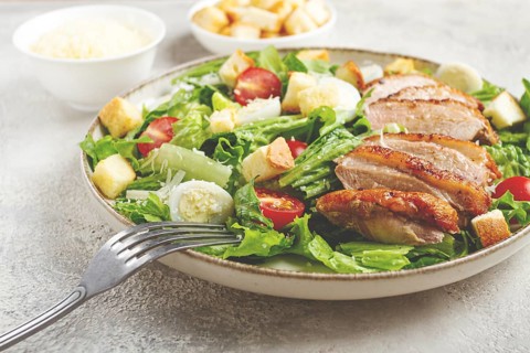 Caesar salad, with duck breast, on a light plate, on a light background, homemade, no people