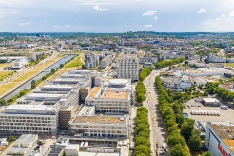 City landscape with river, buildings and parks along the banks from a bird's eye view, airfield,