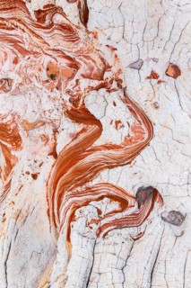A close-up aerial photograph capturing the intricate patterns and textures of abstract red and
