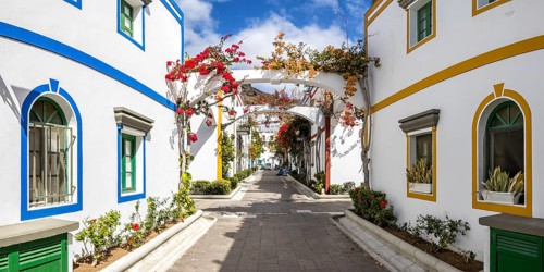 Puerto de Mogan typical colorful houses with flowers on Gran Canaria island panoramic vacation trip