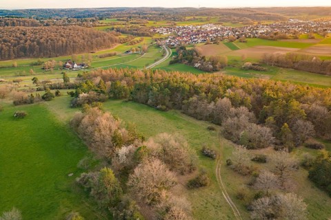 Village view with surrounding forests and fields in a gentle hilly landscape, e-bike tour, old
