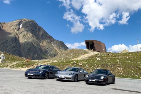 View of two Porsche 911s a Cayman in parking lot at the top of the Alpenpass Timmelsjoch