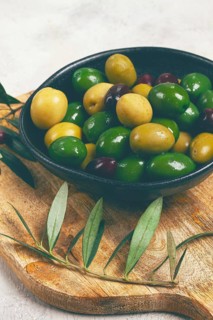 A mixture of olives, varieties of chalkidiki, Verdi giganti and Kalamata, in a bowl, top view, no