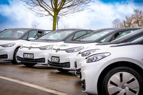 Several white electric vehicles park side by side on a street, Deer charging stations, Calw,