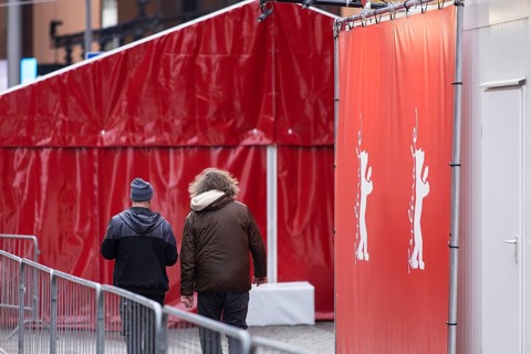 Two workers next to the Berlinale Bear in front of the opening of the 76th Berlinale at the Theater