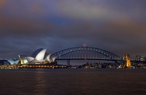 Captivating night view of Sydney Harbor, featuring the illuminated Opera House and Harbour Bridge