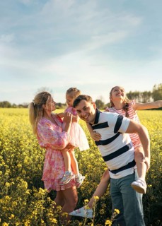 A family, mom, dad and two daughters are having fun together in nature. Family values