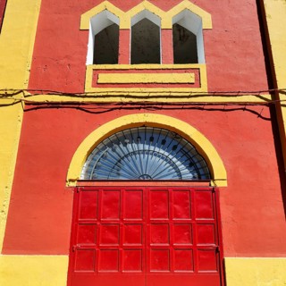 Facade detail, historic bullring, red and yellow, Plaza de Toros, Merida city center, visitors,