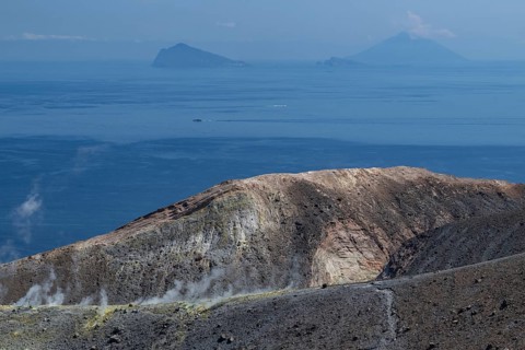 Crater rim, sulfur vapors rising, in the background Panarea and Stromboli volcano, Vulcano, Aeolian