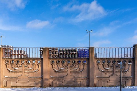 Menorah, seven-armed Judaism chandelier, on a wall in winter, stacks of beer barrels and crates