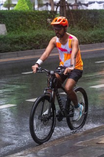Cyclists in rain, Bangkok, Thailand