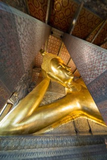 The monumental reclining Buddha shows the moment of entry into Nirvana. Golden surfaces, delicate