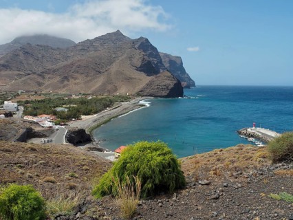 Small bay with village and coastal landscape, surrounded by mountains and clear water, La Aldea de