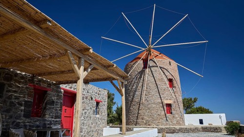 Stone windmill with red elements and adjacent covered patio, Trypiti, Tripiti, village, Milos,