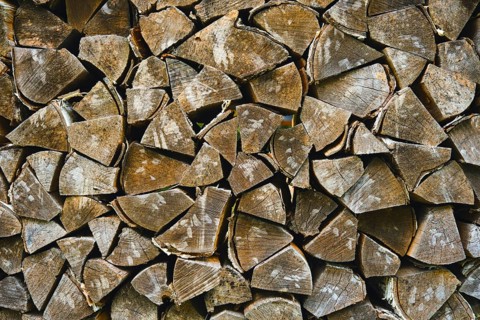 Wood logs arranged neatly for use in heating homes during winter months in rural location. Logs