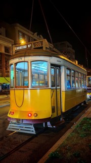 Historic yellow tram brightly lit at night in Lisbon, Lisbon, Portugal