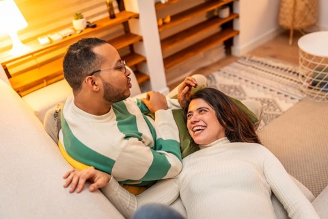 Happy young couple enjoying a comfortable moment on the sofa, finding joy and connection in shared