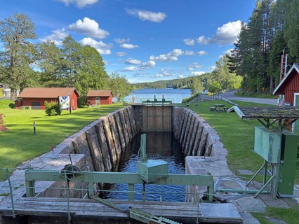 Quiet lock in rural countryside with views of the lake and surrounding wooden houses under blue