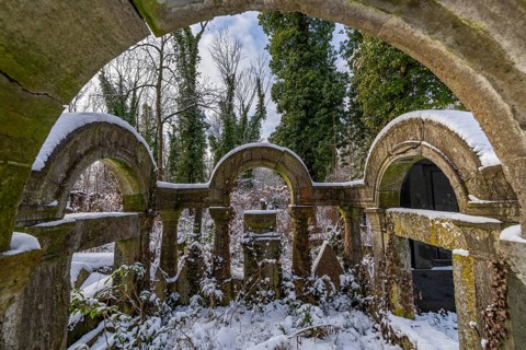 Tomb covered with plants and covered by snow in winter, Weissensee Jewish Cemetery, Berlin
