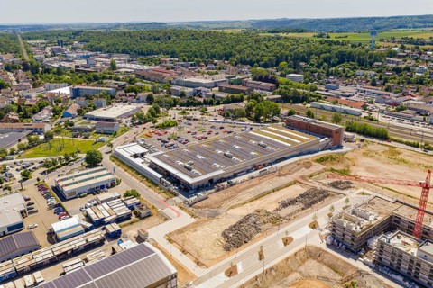 Wide-angle view of an urban landscape with industrial buildings, solar panels and surrounding