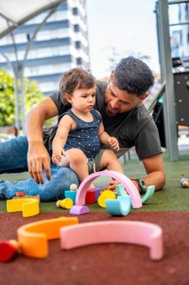 Father and young child enjoying quality time together, playing with colorful wooden building blocks