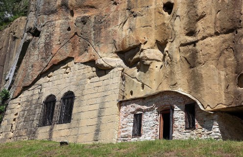Corbii de Piatra rock monastery, stone ravens carved into a massive, 30-meter high sandstone wall,