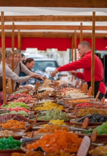 A lively market day with colorful sweets, where people shop at wooden stalls, Majorca, Balearic