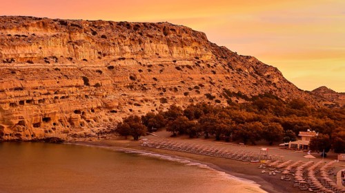 Neolithic caves, former hippie paradise, sunrise on a coast with rocks, quiet beach and a calm sea,