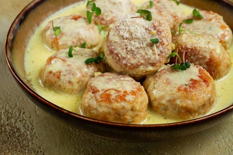 Chicken meatballs, in cream sauce, garnished with parmesan cheese, and microgreens, homemade, no