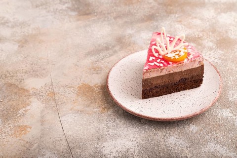 Chocolate cake on brown concrete background, side view, copy space