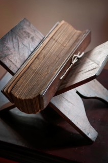 Ancient palm leaf writings on Ayurvedic themes lie on a wooden stand, Harivihar Ayurvedic Heritage