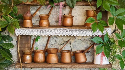 Decorative copper pots arranged on a shelf with plants, tavern, Meronas village, Meronas, Amari