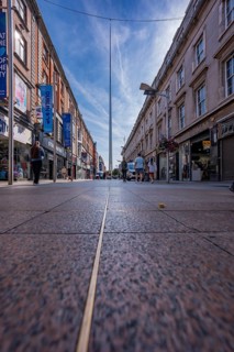 Downtown street with buildings and shops, people in background, clear sky, Dublin, Ireland