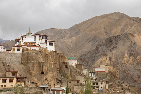 A picturesque view of a monastery perched on rugged cliffs in the serene Zanskar Valley, Ladakh,