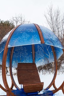 Close-up of backlit blue tinted plexiglass and curved wood panels canopy decorated with white maple