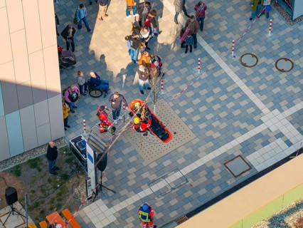 People on a paved square at an event with marked areas, hospital opening, Calw, Germany