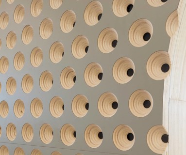 Close up of a modern club wall with a geometric design. The pattern features concentric wooden