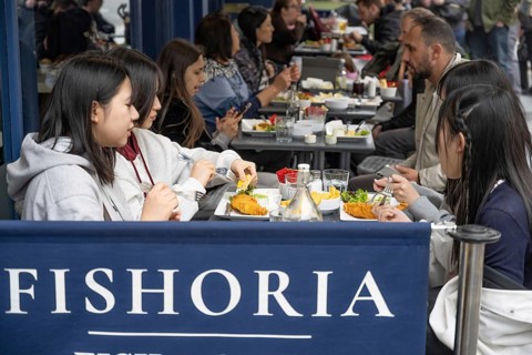 London, United Kingdom. April 17th 2026. Foreign tourists eating fish and chips in a central London
