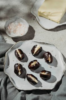 A plate of succulent dates stuffed with creamy butter and sprinkled with sea salt. The rustic