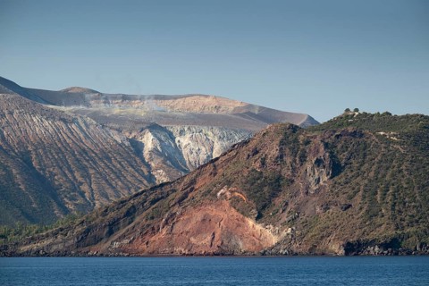 Craters with sulfur vapors seen from the sea, rocky coast, Vulcano, Aeolian or Lipari islands,