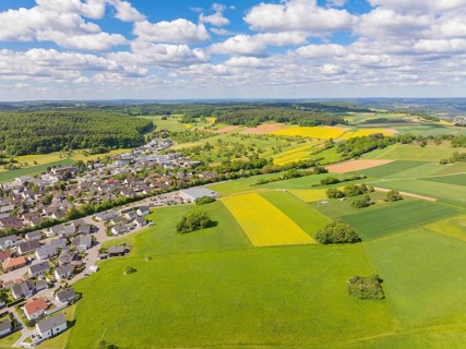 Aerial view of a farming village with wide fields and a lively sky, Gechingen, Black Forest,