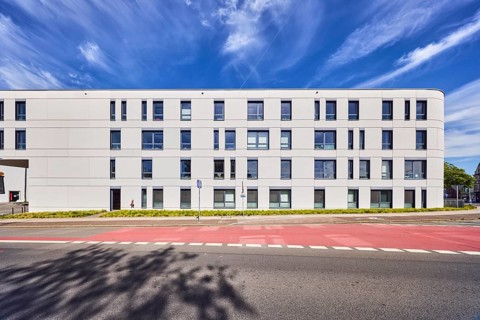 Town hall, modern architecture, commercial building, façade with windows, sidewalk, street, lawn,