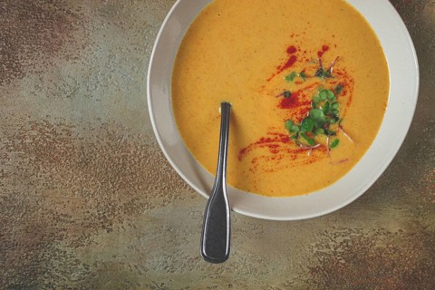 Pumpkin cream soup, in a white bowl on a textured background, top view, homemade, no people, rustic