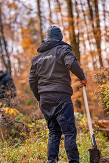 Person with shovel in the forest, Waldbike logo on jacket, tree planting campaign, Waldbike Calw,